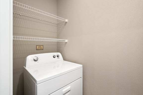 A white washing machine sits in a laundry room.