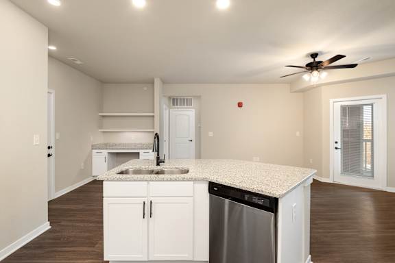 A kitchen with white cabinets and a granite countertop.