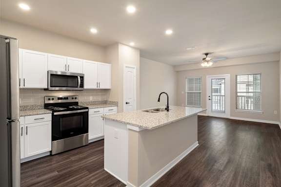 A kitchen with white cabinets and a black stove top oven.