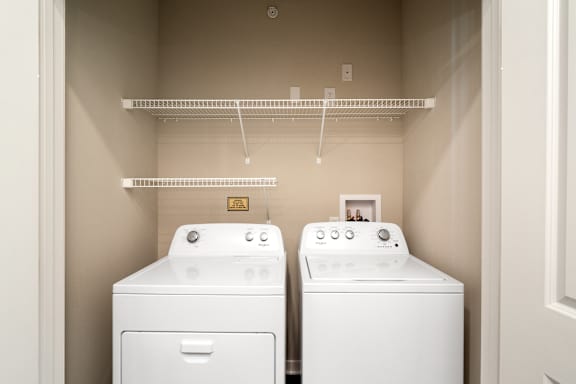 A white washing machine and dryer in a small laundry room.