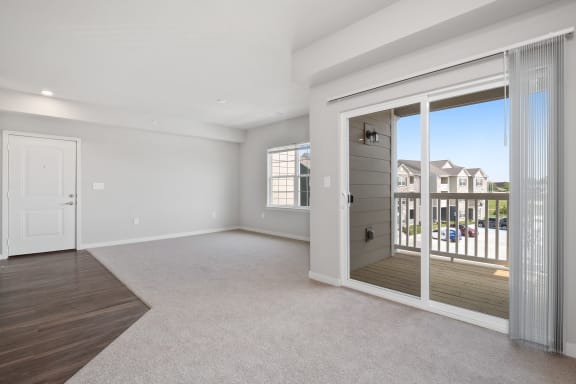 an empty living room with a door to a balcony
