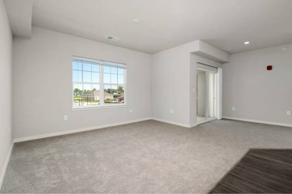 A large empty room with a window and a door at Aventura at Wentzville I & II Apartments, Wentzville, Missouri