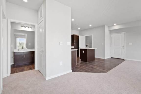 A spacious living room with a kitchen area in the background at Aventura at Wentzville I & II Apartments, Missouri, 63385