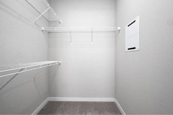 A white closet with a shelf and a hanger on the wall at Aventura at Wentzville I & II Apartments, Missouri, 63385