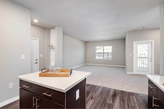 A kitchen with a white countertop and dark wood cabinets at Aventura at Wentzville I &amp; II Apartments, Wentzville, Missouri