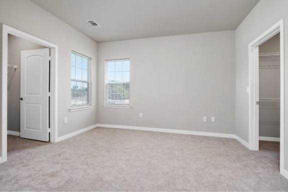 A room with a carpeted floor and two windows at Aventura at Wentzville I &amp; II Apartments, Missouri, 63385