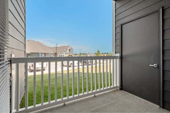 A black door is on the right side of a balcony at Aventura at Wentzville I &amp; II Apartments, Wentzville, MO, 63385