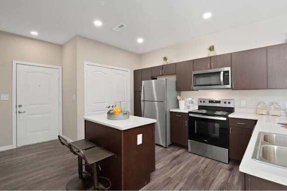 A kitchen with brown cabinets and a white island.