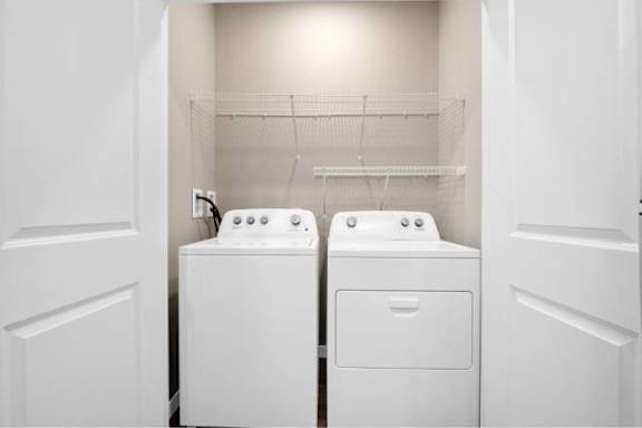 A white laundry room with two washing machines.