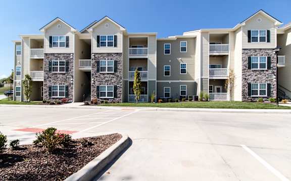 A large apartment complex with multiple buildings and a parking lot in front.