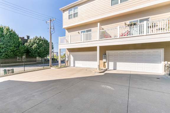 A two-story residential building with a balcony and a garage.