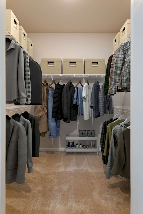 A walk in closet with clothes hanging on shelves and drawers.