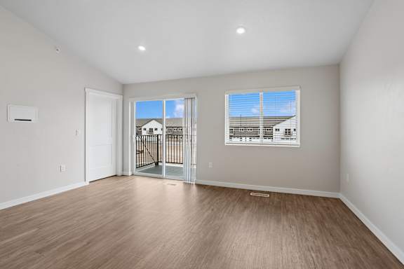 A room with a sliding glass door leading to a balcony.