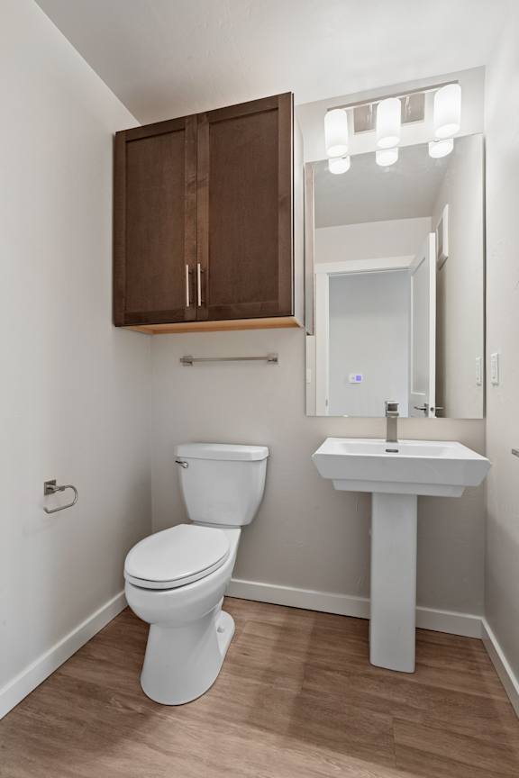 A white toilet and sink in a small bathroom.