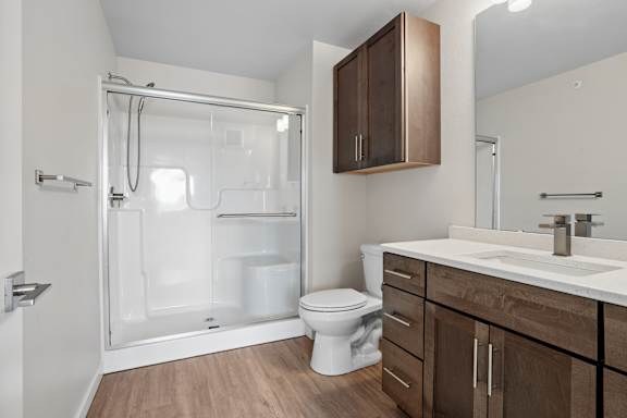A bathroom with a toilet, sink, and shower.
