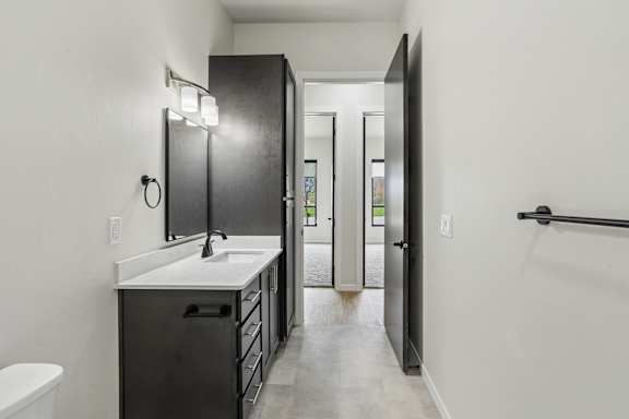 A bathroom with a sink, mirror, and toilet.