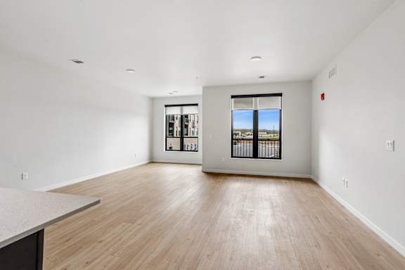 A large empty room with a window and a counter.