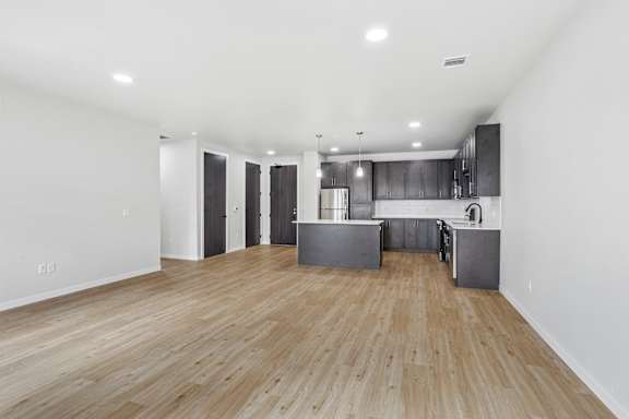 A kitchen with a wooden floor and a large island in the middle.
