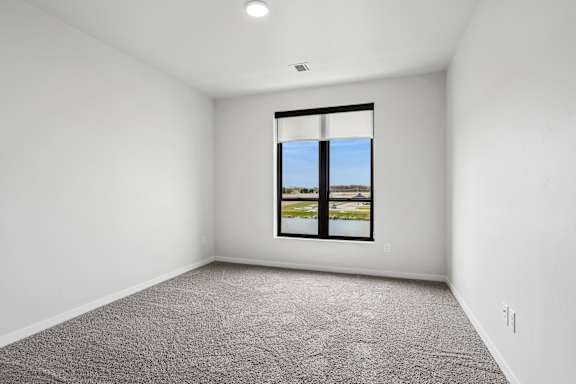 A room with a large window and carpeted floor.