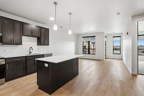 A modern kitchen with dark wood cabinets and a white countertop.