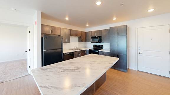 A kitchen with a marble countertop and modern appliances.