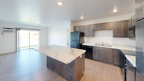 A kitchen with a marble island in the middle of the room.