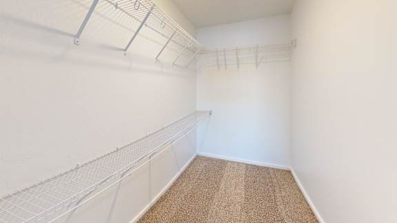 A room with white walls and a carpeted floor with a white fence on the wall.