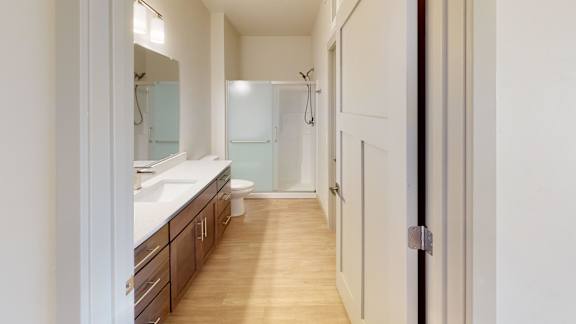 A bathroom with a sink, toilet, and mirror.