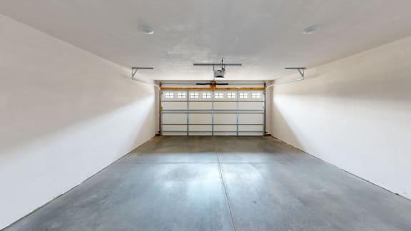 the inside of a garage with a steel door and concrete floor