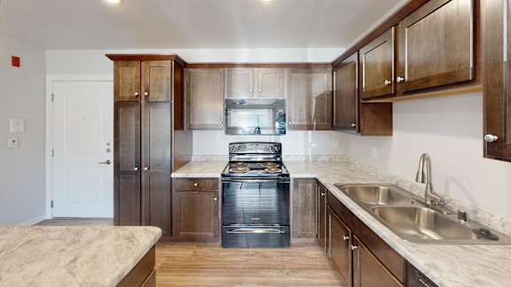 Floor Plan  A kitchen with wooden cabinets and a stainless steel sink.