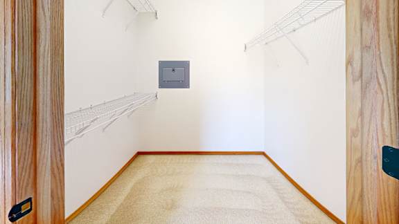 A room with a white wall and a grey electrical box.