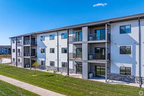 A modern apartment building with balconies and multiple windows.