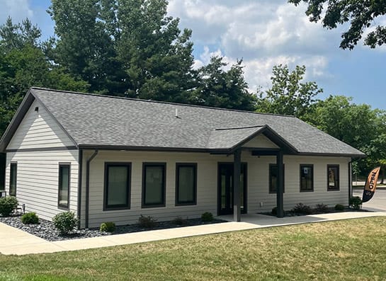 a home with a gray roof and white siding