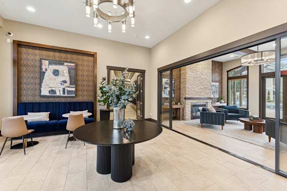 A modern living room with a blue sofa and a large painting on the wall.