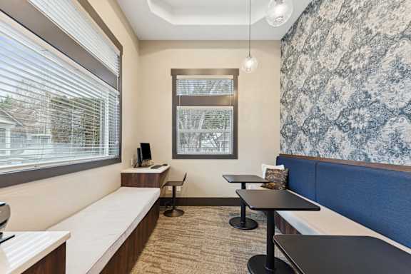 A room with a window, a desk, and a bench.