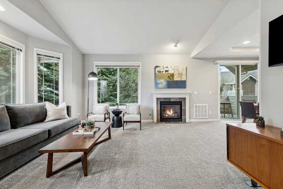 A modern living room with a fireplace and a painting on the wall.