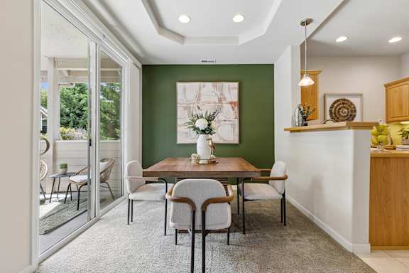 A dining room with a table set for four.