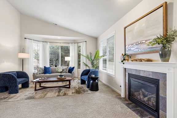 A living room with a fireplace and a painting on the wall.