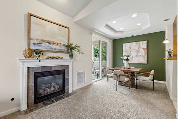A living room with a fireplace and a painting on the wall.