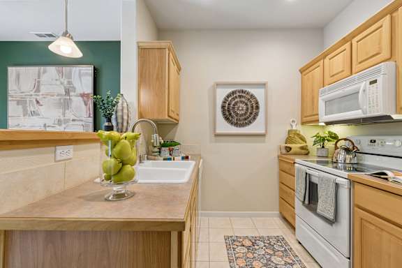 A kitchen with wooden cabinets and a white oven.