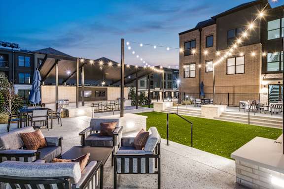 A patio with outdoor furniture and string lights.