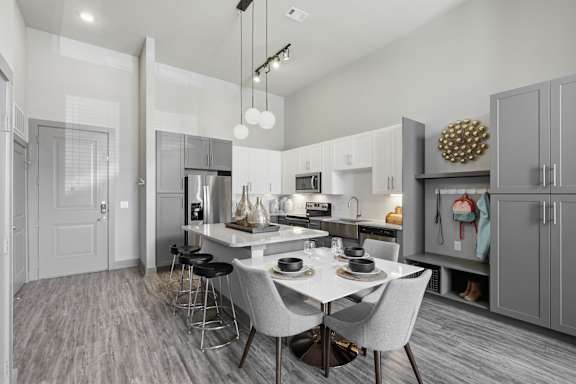 A modern kitchen with a dining table and chairs.
