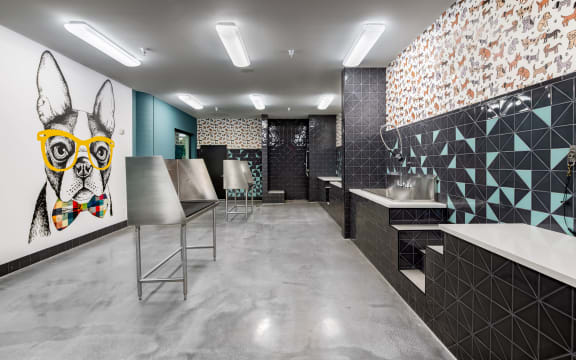 a public restroom with a dog painting on the wall