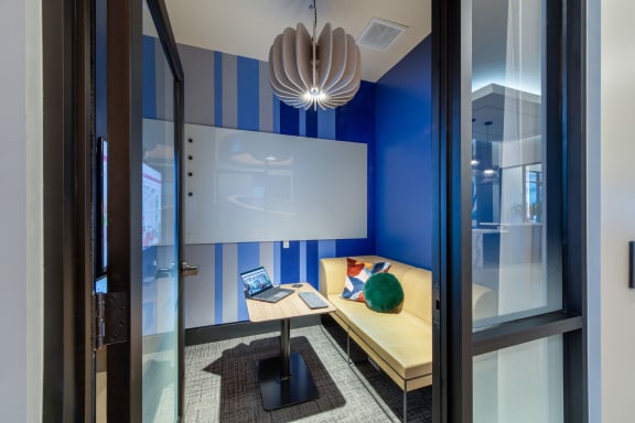 a desk with a laptop in a room with a window