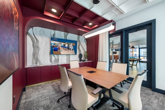 a conference room with a table and chairs and a tv