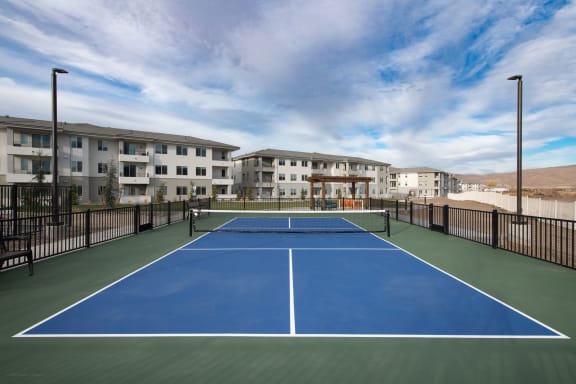 a pickleball court with apartments in the background