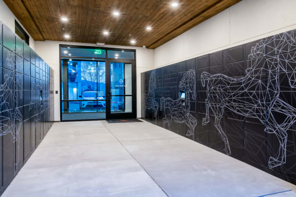 the lobby of a building with a door and a wall with a graphic on it