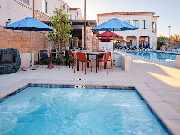 A pool with a table and chairs around it.