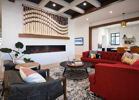 A living room with a red couch and a wooden coffee table.