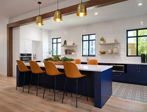 A kitchen with a long island and chairs.